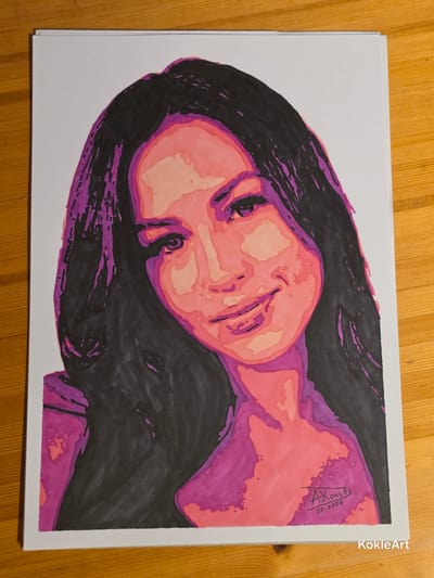 The image is a portrait drawing of a woman with dark hair and a smiling expression. The portrait is rendered in a stylized manner with bold lines and vibrant colors, primarily shades of pink, purple, and black. The woman's face is turned slightly to the left, and her eyes are looking forward. Her hair is long and appears to be dark. The drawing is on a white background and is placed on a wooden surface. In the lower right corner of the drawing, there is a signature that reads "A. Kokle" with a date "07.2026" underneath. There is also a watermark in the bottom right corner of the overall image that says "KokleArt". The scene appears to be indoors, on a table with a visible wood grain. There is no information within the image or its context provided that allows for the identification of the city of Melhus, Norway, or any specific location within it.