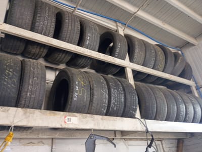 The image shows a set of tires on shelves. The shelves appear to be made of wood and are painted white. The tires are various sizes and have writing on them, likely indicating their size. The location is likely a tire shop or garage in Clarksville, United States of America.