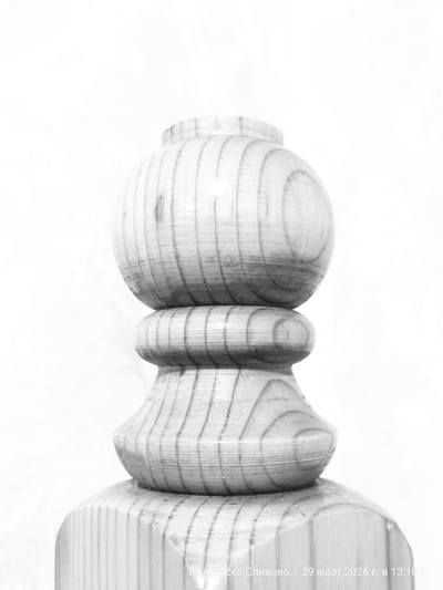 A close-up, black and white photograph depicts a turned wooden object, likely a table leg or decorative element. The object is composed of several distinct shapes: a rounded ball at the top, a cylindrical section, followed by a bulbous, flared section, and a more substantial cylindrical base. Wood grain is prominently visible. The background appears to be a blurry, light-colored surface. Text at the bottom reads: "Българско Сливово | 29 март 2026 г. в 13:10 ч.", which translates to "Balgarsko Slivovo | March 29, 2026 at 13:10". This indicates the photograph was taken in the town of Balgarsko Slivovo, Bulgaria. The time is indicated using the 24-hour clock.