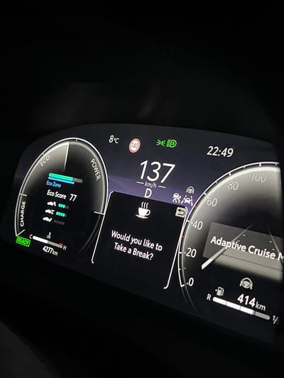 The image shows a car dashboard. The time is 22:49 and the outside temperature is 8°C. The car is traveling at 137 km/h in drive mode (D). Adaptive Cruise Control is engaged. A message suggests taking a break. The fuel tank is approximately 1/4 full and the car has traveled 414 km on this tank. The Eco Score is 77. The car has a total mileage of 4277 km. There is no information to conclude the location of the car is in Shishmantsi, Bulgaria.