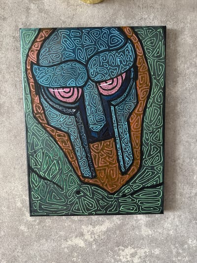 This is a media file of a painting displayed on a textured grey surface. The painting is a rectangular canvas with an abstract image. The artwork features bold lines and vibrant colors, primarily blue, pink, brown, and green, set against a dark background. The blue areas are filled with intricate, swirling patterns, while the pink appears as circular shapes within the blue. Brown and green lines form distinct shapes and patterns that frame the blue and pink elements, creating a sense of depth and movement. The overall style is abstract and stylized, with a focus on pattern and form rather than realistic representation. There is no visible text in the image. The context provided suggests the location is Kondopoga, Russia, but this information is not discernible from the image itself.