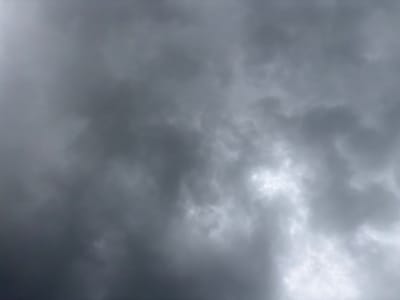The image is a close-up, low-angle shot of a cloudy sky. The clouds are dark and overcast, with some areas appearing brighter where light is breaking through. The texture of the clouds is varied, with some appearing wispy and others dense. The overall impression is that of an impending storm. The image was taken in Grapevine, United States of America. No people, subjects, objects, or actions are visible.