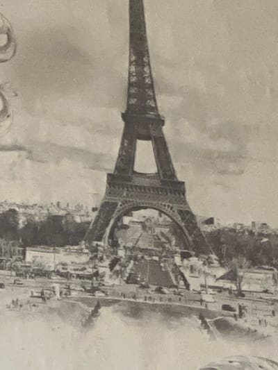 The image depicts the Eiffel Tower in Paris, France, surrounded by buildings and the Seine River. The sky is cloudy.