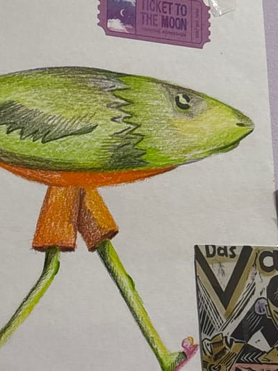 The image displays a drawing of a green, fish-like creature with orange shorts and green legs walking on pink roller skates. The creature has a pointed head with a single eye. Above the creature, there is a purple ticket that reads "TICKET TO THE MOON GENERAL ADMISSION SEAT NO. 1004". To the right of the creature, there is a portion of a black and white illustration that includes the word "Das" and a large "V". The drawing is on a white surface, possibly paper. The background is a plain white or light grey. There are no indications of a city, location, or specific environment related to Jrarat, Armenia.