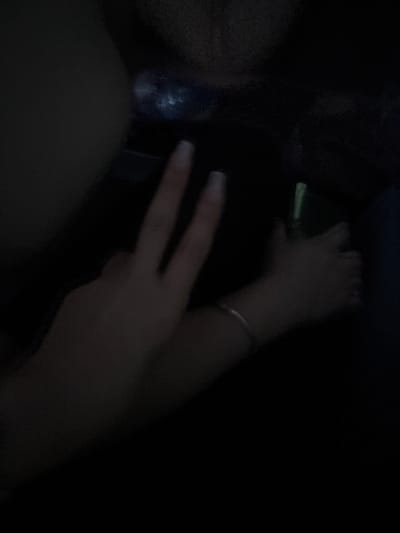 The image, underexposed and blurred, shows a partial view of a person in a dark setting. The person is making a peace sign with their right hand, which has long nails with white tips and a bracelet on the wrist. The background and surrounding environment are obscured due to the lack of light. There are no elements that confirm the location is Krichim, Bulgaria.