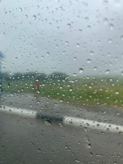 The image shows a close-up view of raindrops on a window, with a blurred outdoor scene in the background. The foreground is dominated by numerous water droplets of varying sizes, creating a textured and somewhat distorted view of what lies beyond.
In the background, a road with a white line is visible, suggesting it is a street or highway. Beyond the road, a green, grassy area is present, possibly a field or park. The sky appears overcast and gray, consistent with rainy weather. There are no people or specific identifiable structures visible in the cropped portion of the background. The overall impression is a serene, yet slightly melancholic, scene of a rainy day.
The location provided, Курапольскі сельскі Савет, Belarus, suggests a rural or semi-rural area within Belarus. This context aligns with the observed elements of a road, fields, and the absence of dense urban development. The weather conditions depicted are typical of various regions during periods of rainfall.