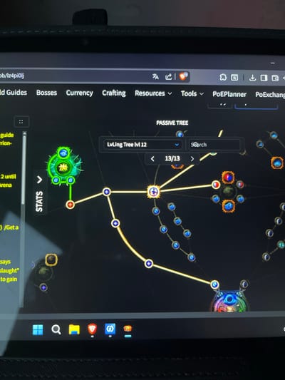 The image shows a screenshot of a computer screen displaying a game interface, likely a skill tree or character progression system from the game "Path of Exile". The interface features a dark background with glowing nodes and connecting lines representing skills. Text elements like "PASSIVE TREE", "LvLing Tree lvl 12", "13/13", and "Search" are visible. There are also menu bar items such as "World Guides", "Bosses", "Currency", "Crafting", "Resources", "Tools", "PoEPlanner", and "PoEExchange". A vertical sidebar on the left displays text like "guide", "rrion-", and "2 until Arena". The bottom of the screen shows a Windows taskbar with icons for the Start menu, search, file explorer, a game launcher, and possibly other applications. The overall scene depicts a digital interface being used on a laptop or computer. There is no discernible information about the city of Kohtla-Järve linn, Estonia, or any people in the image.