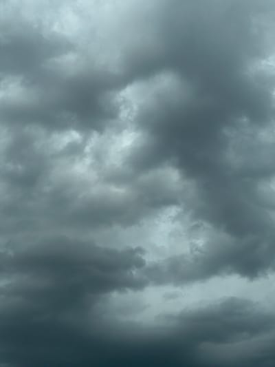 This media file is a close-up, high-angle, full shot of a turbulent, dark gray storm cloud formation. The clouds are dense and textured, with lighter, almost white patches interspersed within the darker masses, suggesting a dramatic and potentially impending weather event. The overall impression is one of ominousness and power, characteristic of a severe storm. The lighting is dim, indicative of a heavily overcast sky, likely during daytime but with conditions that obscure direct sunlight. There is no discernible location or scene beyond the clouds themselves. No people, objects, text, or specific activities are visible. The setting is exclusively the sky, dominated by the menacing cloudscape. The weather appears to be stormy, with the dark clouds hinting at rain or other severe atmospheric conditions. Given the context of Sânnicoară, Romania, this image captures a natural phenomenon occurring in that geographical area.