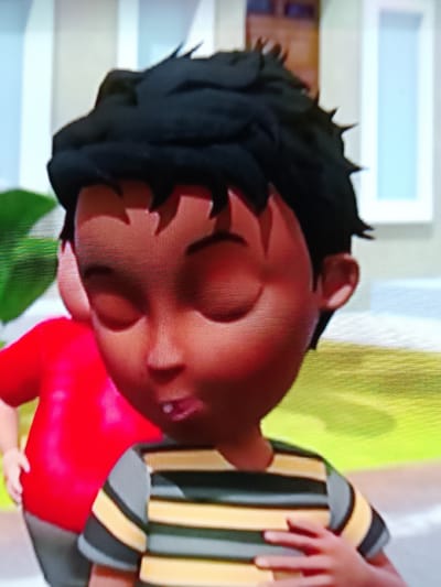 This is a close-up, slightly pixelated, animated 3D render of two young boys outdoors. The primary subject is a boy in the foreground with dark, spiky hair and brown skin, wearing a horizontally striped shirt in black, yellow, and grey. His eyes are closed, and his mouth is slightly open. His right hand is placed on his chest. Behind him and to the left, a second boy is visible, wearing a bright red shirt. The background is blurred but suggests an outdoor setting with green foliage and a building facade with vertical white and blue elements. There is no indication of the city of Merbopuntong, Indonesia, within the image.