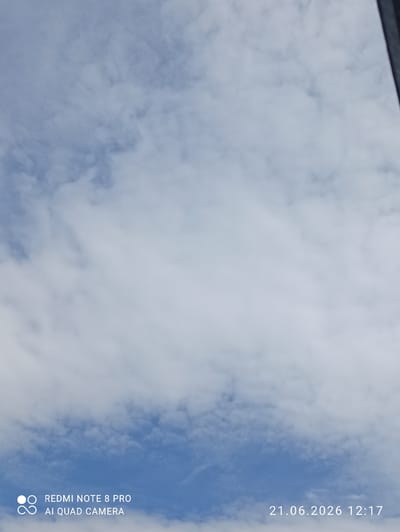 This is a full shot of a cloudy sky, with a bright blue sky peeking through the clouds. The image has a timestamp in the bottom right corner that reads "21.06.2026 12:17", and a camera model designation in the bottom left corner that reads "REDMI NOTE 8 PRO AI QUAD CAMERA". There are no people or man-made structures visible in the image. The location in the city of Sovetskiy, Russia is not discernible from the image itself.
