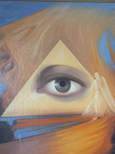 The image is a close-up of a painting, featuring a large, central eye within a triangle. The eye is realistic, with a dark pupil and iris, and appears to be looking directly forward. To the right of the eye, a figure in a flowing, light-colored robe, reminiscent of an angel, is depicted. The background is abstract, with swirling colors of orange, yellow, blue, and brown. The painting has a textured surface, indicating it is likely oil on canvas. The context of Uhersko, Ukraine, is not visible or inferable from the image itself.