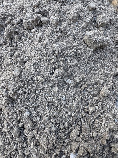 The media file is a close-up, overhead shot of a pile of dry, gray sand. The sand is coarse, with visible grains and small clumps formed by moisture or static electricity. The texture is rough and granular, with variations in light and shadow creating a sense of depth and volume. There are no discernible objects, people, or specific features that suggest a particular location beyond the generic nature of sand. The lighting appears to be even, suggesting it could be daylight, but there are no shadows that indicate a specific time of day or weather conditions. The scene is static and devoid of any activity or narrative. There is no visible text within the image. The context provided, Usinsk, Russia, suggests the sand is likely in an outdoor environment, possibly related to construction, industry, or a natural landscape in that region.