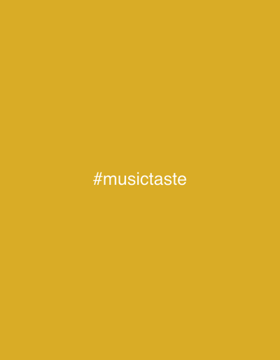 A simple, minimalist image displays the hashtag #musictaste in white text against a solid, mustard-yellow background. The text is centered horizontally and located in the lower middle portion of the frame. There are no other visible elements, subjects, or actions. The image is devoid of any environmental context, including any information about its location in Las Rozas de Madrid, Spain.