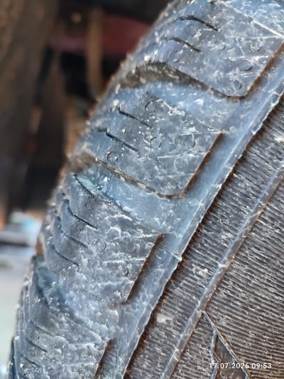 The image shows a close-up of a tire tread, with small droplets of water or condensation visible on its surface. The tire appears to be black and has a patterned tread with several grooves and some small circular indentations. The background is out of focus and shows a blurred environment, possibly suggesting an outdoor setting. A date and time stamp "17.07.2026 09:53" is superimposed on the bottom right corner of the image. The location of Weitnau, Germany is not evident in the image itself.