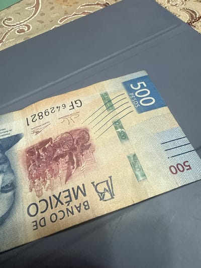 The image shows a 500 Mexican peso banknote resting on a gray surface. The blue section displaying the number "500" and "PESOS" is visible. The text "BANCO DE MEXICO" is vertically oriented on the note. The serial number "GF6429821" is printed on the bill. The image does not give any indication of it being located in San Cristóbal, Mexico.