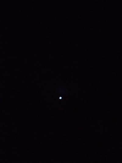 The image shows a dark sky with a small, bright circular object in the center. The object is faintly illuminated and appears to be the moon. The background is uniformly black, suggesting it is nighttime. There is no visible indication of the city of Iyara, Nigeria, or any other specific location within the image. No people, animals, or other objects are discernible. The scene is devoid of any activity or interaction.