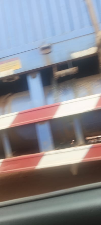 A blurry photograph shows the side of a moving train car. The car is blue on top with a red and white striped section below. The location is unknown.