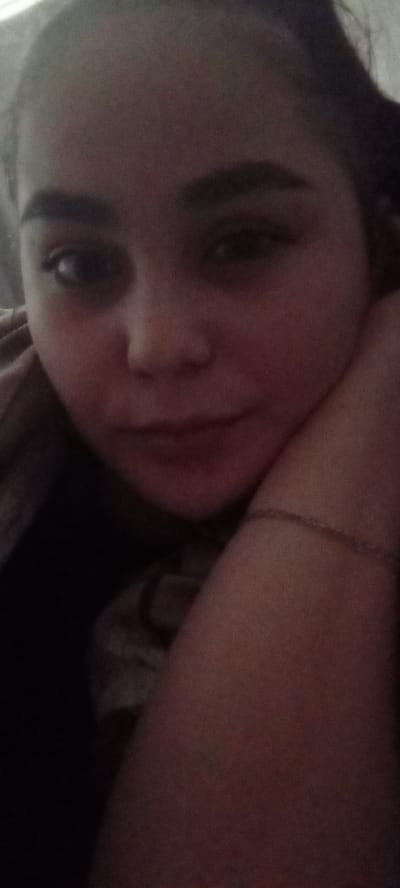 A close-up indoor portrait shows a woman with dark hair resting her head on her arm. A delicate bracelet is visible on her arm. The location in the city of Dyurtyuli, Russia, cannot be determined from this image.