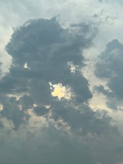 The image captures a dramatic sky filled with dark, brooding clouds, characteristic of impending rain or a storm. A bright, golden patch of sunlight breaks through a gap in the dense cloud cover, creating a striking contrast. The overall scene is one of atmospheric intensity, with the light filtering through the clouds suggesting a powerful natural phenomenon. The location is identified as Golyamo Vranovo, Bulgaria. There are no people or man-made objects visible in the frame, focusing solely on the natural elements of the sky.