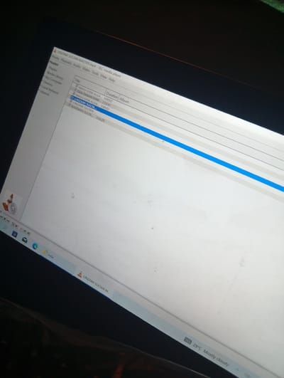 The image shows a laptop screen displaying a VLC media player window. The player is open and shows a playlist with several song titles, including "MASU GIDA ALGA," "DAN DAGAN MAW," and "LINZAMI SULTAN." The screen is partially obscured by darkness, suggesting the room is dimly lit. The VLC media player icon is visible on the taskbar, alongside other program icons. The overall scene suggests a user is listening to music on their laptop. There is no visible indication of the city of Mallam Sidi, Nigeria.