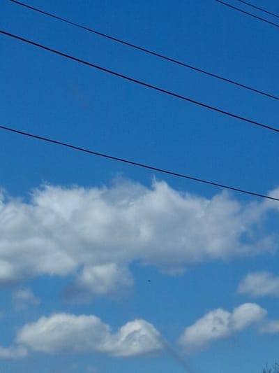 The image presents a daytime view of a clear blue sky interspersed with white, fluffy clouds. Three dark, seemingly parallel wires are positioned on the left side of the frame. The image does not provide sufficient information to determine the specific location or details about people, subjects, objects, actions, or interactions within the scene, nor can the location in Studeno Buche, Bulgaria, be confirmed based on this image.