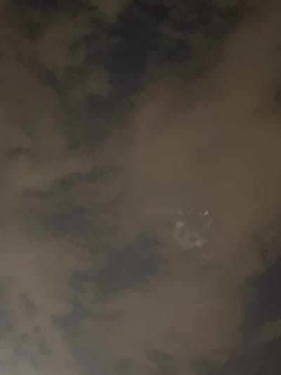 The image depicts a dark, cloudy sky with some bright, ethereal lights scattered throughout. These lights appear to be concentrated in the upper center of the frame, suggesting a potential celestial event or an artificial light source in the distance. The clouds are a mix of dark grays and lighter browns, creating a textured and somewhat turbulent atmosphere. The overall impression is one of mystery and awe, with the bright lights contrasting sharply against the somber sky.
The time of day is unclear, but the darkness of the clouds suggests it could be evening or night. There are no specific location cues visible in the image, only the general context of Grapevine, United States of America. The activity or event taking place is not discernible, but the presence of the lights might indicate a distant phenomenon. The notable details are the contrast between the dark clouds and the bright, possibly scattered lights, which evoke a sense of wonder or perhaps unease. There is no visible text in the media file.