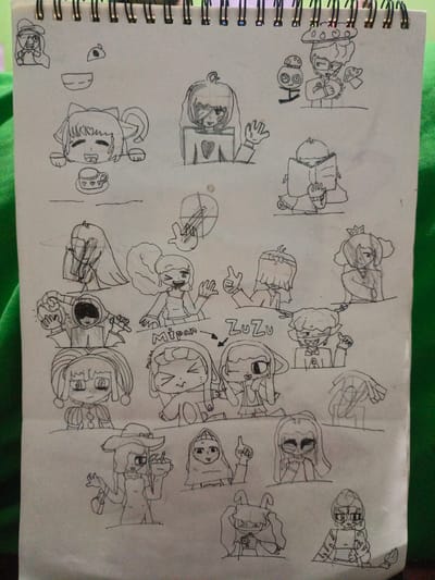 The image is a black and white sketch on a spiral-bound notebook page. The sketches depict various cartoon characters, mostly young women, in different poses and with diverse facial expressions. There are no discernible geographical markers or contextual clues within the artwork that would suggest a specific location in Gampong Blang, Indonesia, or any other city. The content is purely illustrative and does not contain any environmental details relevant to a specific place.