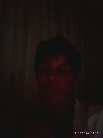 The image is a dimly lit photograph of a person's face, partially obscured by shadows. The person appears to have short, dark hair and is looking towards the camera. The background is dark and indistinct, with vertical lines suggesting curtains or blinds. A timestamp in the bottom right corner reads "10.07.2026 00:11". The image does not provide any information about the location in Nihoreni, Moldova.