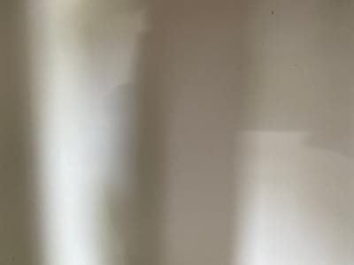 The image is a close-up, overhead view of a light-colored, textured surface, likely a wall or fabric. There are vertical shadows cast across the surface, suggesting an artificial light source or natural light from a window. The shadows are uneven, with some areas being brighter than others. There are a few small, dark specks on the surface, possibly dust or debris. The overall impression is one of a simple, unadorned background.
Given the request to include location details, and noting that the image itself contains no discernible features to pinpoint a location, the provided information is a generic description of the visual content. Without any external context or visual cues within the image to suggest the city of Uzhur, Russia, it is impossible to provide a description that includes this specific location. The image solely depicts a textured surface with shadows.