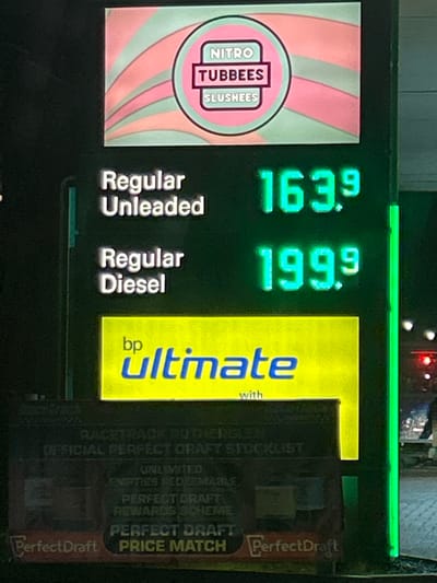 The image shows a gas station sign in Rutherglen, United Kingdom. The sign advertises "Nitro Tubbees Slushees". The price for "Regular Unleaded" gasoline is 163.9 and the price for "Regular Diesel" is 199.9. The sign also advertises "bp ultimate". Additionally, the sign promotes "PerfectDraft Price Match" and lists "Racetrack Rutherglen Official Perfect Craft Stocklist Unlimited Empties Redeemable Perfect Draft Rewards Scheme".