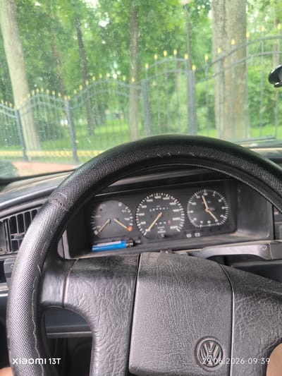 The image shows the interior of a car, focusing on the steering wheel and dashboard. The dashboard has three gauges, including a speedometer displaying 384997 km/h. A blue lighter is placed on the dashboard. The steering wheel is black and textured, with some wear visible. Outside the car, trees and a decorative metal fence can be seen, suggesting an outdoor setting, possibly in a park or residential area. The timestamp in the bottom right corner indicates June 29, 2026, at 09:39. The Xiaomi 13T watermark is present in the bottom left corner. The scene implies the car is parked or stationary. Without additional information or context, it is not possible to determine the specific location within the city of Vileyka, Belarus.