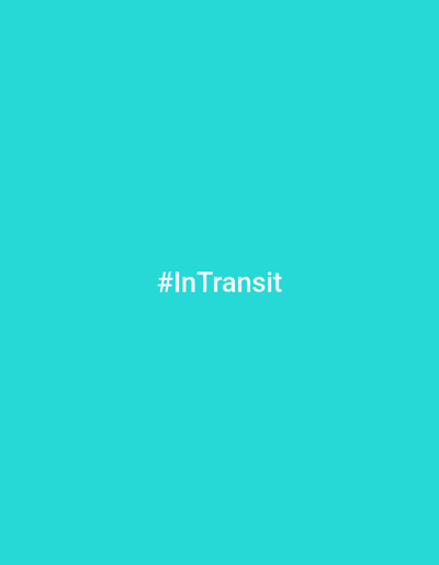 The image is a plain, bright cyan background with the hashtag "#InTransit" in white, sans-serif font centered horizontally. There are no other objects, people, or environmental features present in the image. The location in the city of Balice, Poland, is not depicted in this image.