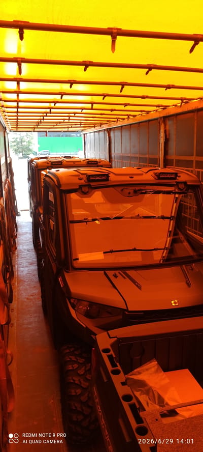 The image shows the interior of a cargo trailer or truck with a bright yellow tarp covering the roof and sides. Several utility vehicles, possibly ATVs or UTVs, are parked in a row inside the trailer. The vehicles are dark colored with orange-tinted windshields and roofs. Some of the vehicles have lighting fixtures on their roofs. The trailer floor is dirty and worn. The image is taken from a low angle, looking towards the back of the trailer. The lighting inside the trailer is dim, with a strong orange hue. The scene appears to be in a storage or transport area. There are no people visible in the image. The timestamp on the image reads "2026/6/29 14:01". The logo "REDMI NOTE 9 PRO AI QUAD CAMERA" is visible in the bottom left corner. Based on the available information, it is not possible to determine the specific location in Valga city, Estonia.