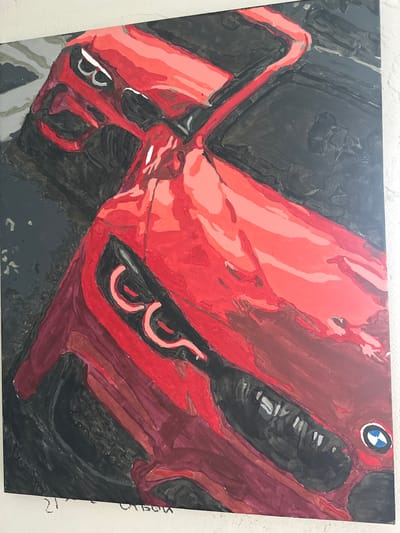 The image is a painting of a red BMW car, viewed from above, with a dark background. The painting is abstract and uses broad brushstrokes. The car's headlights are visible and stylized. The BMW logo is present on the front of the car. The painting is hanging on a wall. There is no indication of the city of Podilsk, Ukraine, or any other location in the image.