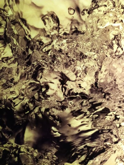 The image is a close-up, abstract shot of agitated water. The lighting creates a dramatic, almost monochromatic effect with strong contrasts between light and dark areas, highlighting the textured surface of the water. Bubbles and ripples are visible, suggesting movement and turbulence. The overall impression is one of dynamic natural forces. The bottom right corner of the image contains a timestamp: "2026.06.17 02:43". There are no visible elements in the image that can definitively place it in the city of Houthalen, Belgium, or any specific urban environment.