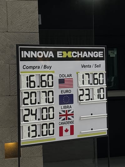 The image shows an exchange rate display for INNOVA EXCHANGE. The display indicates the "Compra/Buy" and "Venta/Sell" rates for various currencies. The rates are displayed using a digital number display. The image shows the U.S. dollar, the Euro, the British Pound and the Canadian dollar. The rates for the "Compra/Buy" side are as follows: $16.60 for the U.S. dollar, $20.70 for the Euro, $24.00 for the British Pound, and $13.00 for the Canadian dollar. The "Venta/Sell" rates displayed are $17.60 for the U.S. dollar, and $23.10 for the Euro. The other selling rates are not available. The image was taken in Ciudad López Mateos, Mexico.