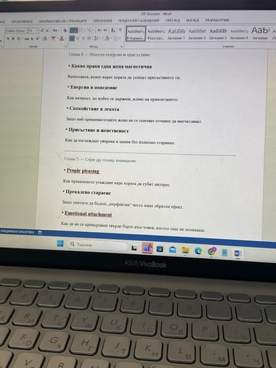 The image is a photograph of a laptop screen displaying a Microsoft Word document. The document is written in Bulgarian and appears to be a chapter from a book or article on the topic of female energy and presence. The laptop is an ASUS VivoBook with a silver keyboard. The screen also shows the Windows taskbar with icons for various applications. The image is taken indoors, likely on a desk or table.