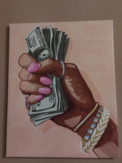 An oil painting on canvas depicts a hand holding a fan of US hundred-dollar bills. The hand is dark-skinned with long, pink, almond-shaped fingernails. Several rings are visible on the fingers, and a blue band is worn on the wrist. A thick bracelet with gold accents and clear stones adorns the forearm. The background is a pale pink, and the painting is framed by a wooden surface. The image does not provide any information about the city of Ostafievo, Russia, or any specific location within it.