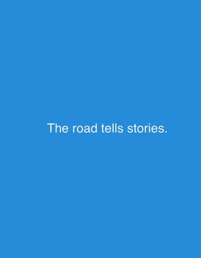 The image is a static shot of a solid blue background with white text overlaid. The text reads: "The road tells stories." There are no people, objects, actions, or interactions visible in the image. The background is a uniform shade of blue. The image does not provide any information or context related to the city of Nalazar, Uzbekistan.