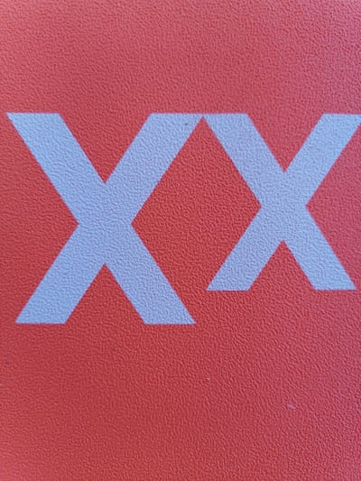 The image displays the letter "XX" in white against a textured, orange background. The "X"s are large and centered, taking up most of the frame. The texture of the background appears to be a bumpy or pebbled surface, possibly a mat or a fabric. The image is a close-up shot, with no surrounding environment visible. There are no people, actions, or interactions depicted. The location in Durankulak, Bulgaria is not discernible from the image itself.
