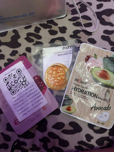 The image shows three facial sheet masks laid out on a leopard-print fabric. From left to right, the masks are: a pink mask with a QR code and Russian text, a white mask with Chinese text and an image of capsules, and a mask with an image of avocado and ice cream. The mask on the right is labeled "missHelen Fruits Gelato HYDRATION Mask Avocado". The overall scene is a flat lay arrangement of beauty products. There is no indication of Romanovka, Russia.