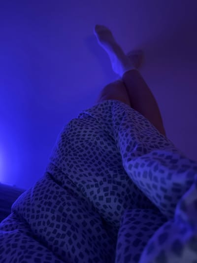 The image shows a person's leg wearing a white sock, and part of a patterned garment against a blue background. The location in Kranj, Slovenia cannot be determined from the given image.