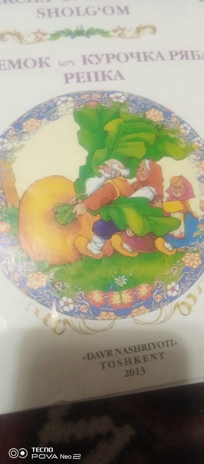 The image is a close-up of a book cover or illustration. The illustration depicts a scene from a fairy tale, likely "The Giant Turnip." In the foreground, several characters are pulling on a large, orange root vegetable with green leaves. The characters include an elderly man with a white beard, a woman in a red headscarf, and a young girl in a pink headscarf. The background features a decorative border with floral motifs. The text on the cover, in Latin script, reads "SHOLG'OM" at the top, followed by what appears to be Russian text "EMOK " КУРОЧКА РЯБА / РЕПКА". At the bottom of the image, there is text that reads "«DAVR NASHRIYOTI» TOSHKENT 2013". This indicates the publisher is "Davr Nashriyoti" and the location of publication is Tashkent, Uzbekistan, with the year 2013. The presence of the Tashkent imprint suggests the item is related to publishing or printing activities within the city of Tashkent, Uzbekistan. The image does not contain any information or visual cues that would place it specifically in the city of Tahmach, Uzbekistan.