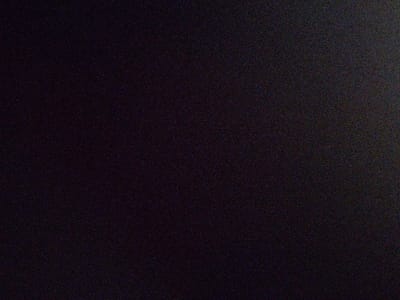 The image is a solid black with a slight grainy texture. It is impossible to describe any details about people, objects, actions, interactions, or the environment because the image is completely black. The provided coordinates (latitude: 33.606, longitude: 73.08) correspond to a location in Rawalpindi, Pakistan, but there is no information about the image's location in the city.