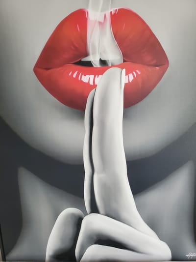The image is a close-up painting of a person's lips and hands. The lips are bright red and appear glossy, with white smoke or vapor emerging from between them. A hand is positioned in front of the lips, with a finger held to them in a "shushing" gesture. The rest of the visible person is rendered in grayscale, with soft shading and highlights that give a sense of form and dimension. The background is a neutral gray. There is a small signature in the bottom right corner of the painting that appears to read "inkfutures". The image does not contain any elements that indicate a specific location within the city of Kitchener, Canada.