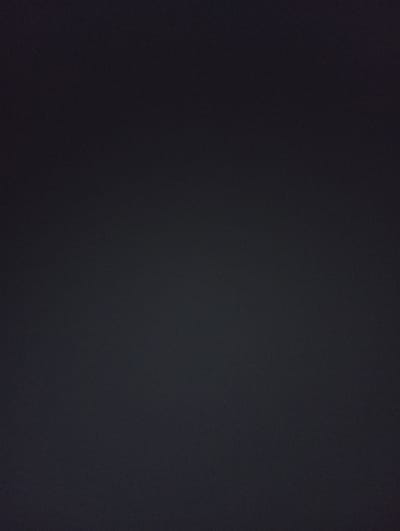 The image is a dark, grainy, solid black background. There is no discernible content, person, object, action, interaction, or environmental detail visible in the image. Therefore, it is impossible to provide any location information or a description of a scene within the city of Ак-Жар, Kyrgyzstan.