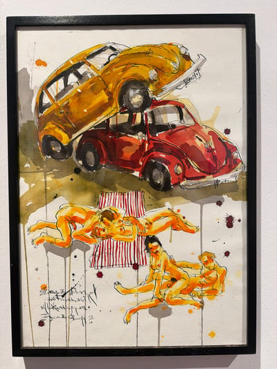This is a framed watercolor and ink drawing of an unusual scene. Two cars, one yellow and one red, are depicted tipped over and on their sides, taking up the left half of the composition. The cars are rendered with loose, expressive brushstrokes and bold black outlines. Splatters of paint in red and yellow suggest a chaotic or dynamic event.
On the right side of the drawing, several nude figures are gathered. They are depicted in various poses, some intertwined and others reclining. The figures are painted in warm orange and yellow tones with simple black linework. One figure appears to be sitting on a striped red and white blanket or mat, while others are positioned around them. The background is a light wash of white with thin horizontal lines, suggesting a flat surface or perhaps a stylized representation of a beach or open space.
There are no explicit cues for time of day or weather. The overall impression is abstract and somewhat surreal, with the juxtaposition of the overturned vehicles and the reclining figures creating a sense of disarray or an unconventional gathering.
Visible text includes some handwritten calligraphy or signatures in the lower right quadrant of the artwork. The characters are in black ink and appear to be a script, possibly Spanish or another language. The overall mood is ambiguous, leaving interpretation open to the viewer.