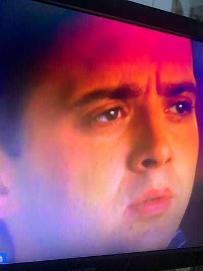The media file is a close-up, vertically oriented photograph of a person's face, likely a woman, shown from a low-angle perspective. The lighting is dramatic and uses a color gradient, with vivid shades of pink, orange, and purple dominating the image. The subject's face is illuminated by this colorful light, creating a surreal and artistic effect.
The person's eyes are open and looking upwards, with a slight glint of light reflected in them. The nose and mouth are also visible, with the lips appearing slightly parted and tinged with pink from the lighting. The skin texture is discernible, showing some pores and subtle variations in tone. The overall impression is one of introspection or perhaps a posed portrait capturing a specific mood.
The background is abstract and blends into the colorful lighting, with no discernible setting or objects. The image appears to be captured on a screen, as evidenced by the pixelated texture visible in the close-ups and the presence of a dark bezel on the right side, which has "PHILIPS" printed on it in white text. This suggests the image might be a screenshot, a photo of a screen displaying a digital artwork, or a scene from a film or video.
No specific time of day, weather conditions, or location cues from Glodeni, Moldova, are evident within the image itself, beyond the possible context provided by the user. The emotion conveyed is ambiguous, leaning towards a contemplative or dreamlike state due to the unusual lighting and the subject's upward gaze.