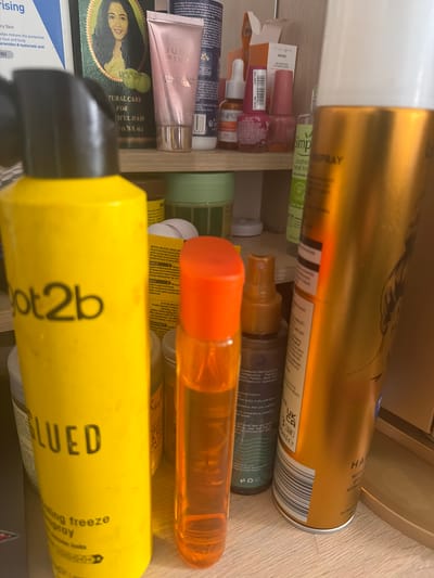 The image shows an overhead view of a shelf or drawer containing various cosmetic and hair care products. Brands and product names visible include "Got2b Glued," "Just Pink," "Cerave," "Simple Soothing Facial Toner," and "Hair Spray." No people are visible. The environment appears to be a personal storage space, such as a bathroom cabinet. The location in Rotherham, United Kingdom, cannot be ascertained from the image alone.