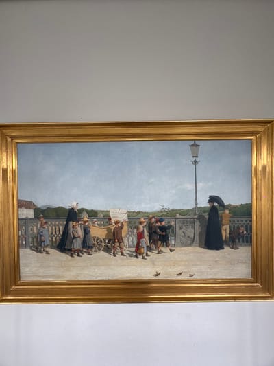 This is a painting in a gold frame, depicting a scene on a bridge or elevated walkway. The viewpoint is from a low angle, looking up at the scene. The sky is overcast, suggesting a daytime setting with perhaps cool or fair weather.
The foreground of the painting shows several groups of people dressed in historical clothing. On the left, a group of children and adults are gathered, some looking towards the viewer, others engaged in conversation. Further back, a woman in a dark, flowing dress holds an umbrella, walking away from the viewer. In the middle ground, a horse-drawn cart with a white canopy is positioned, surrounded by more figures. The people are depicted with detailed clothing and expressions, suggesting a lively or bustling atmosphere.
In the background, a bridge railing with an ornate pattern separates the walkway from a landscape beyond. This landscape includes trees and what appears to be a city with buildings, possibly in Bern, Switzerland, given the location context. A lamppost stands prominently on the walkway, adding to the urban feel of the scene. A few birds are visible flying in the sky.
The painting captures a moment in time, possibly a public gathering or a stroll along the promenade. The overall mood seems relatively calm, though the interaction between the figures suggests a sense of everyday life and social activity. There is some visible cracking in the paint surface, indicative of age. No discernible text is present in the visible portion of the painting.